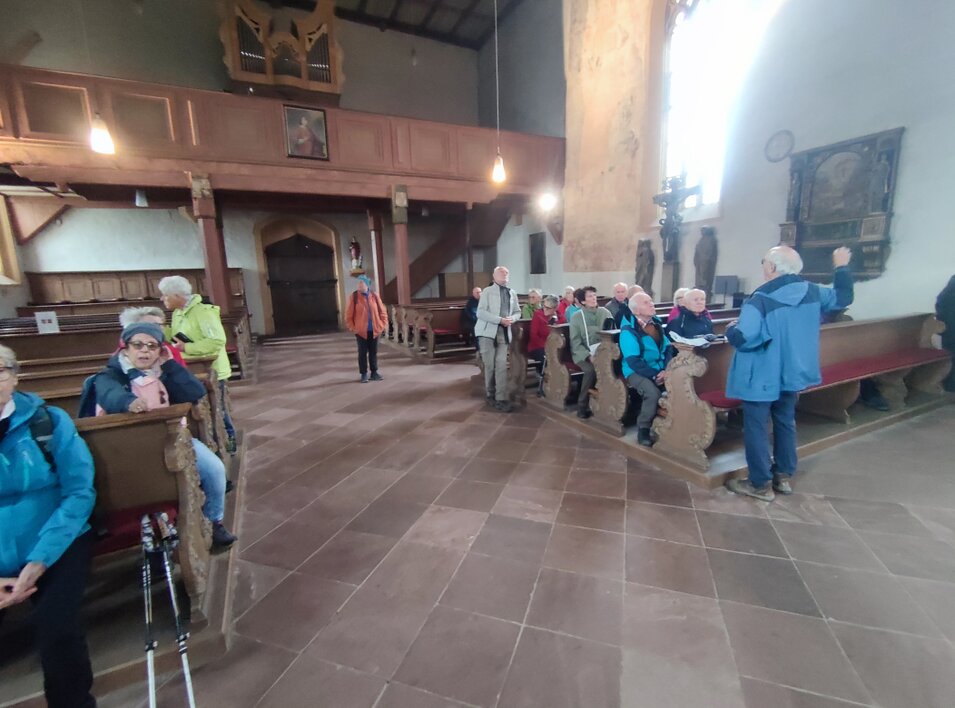 In der Wallfahrtskirche Maria im Weingarten Ludwig Schönbein erläutert die kunstgeschichtliche Bedeutung der Maria im Rosenkranz, einer Skulptur von Tilman Riemenschneider, gefertigt um 1521-1524